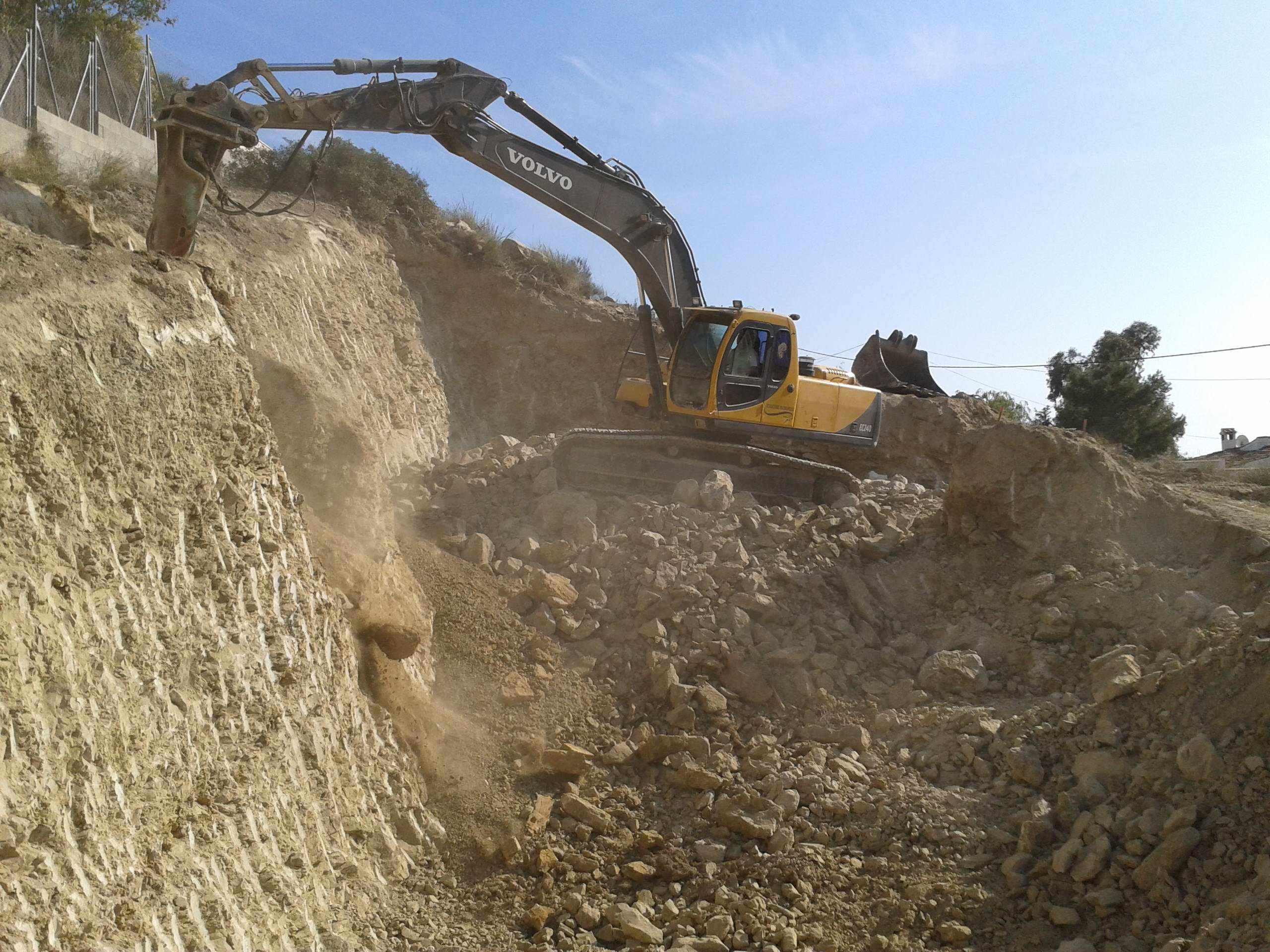 Excavadora de Excavaciones Muchamiel trabajando sobre terreno rocoso